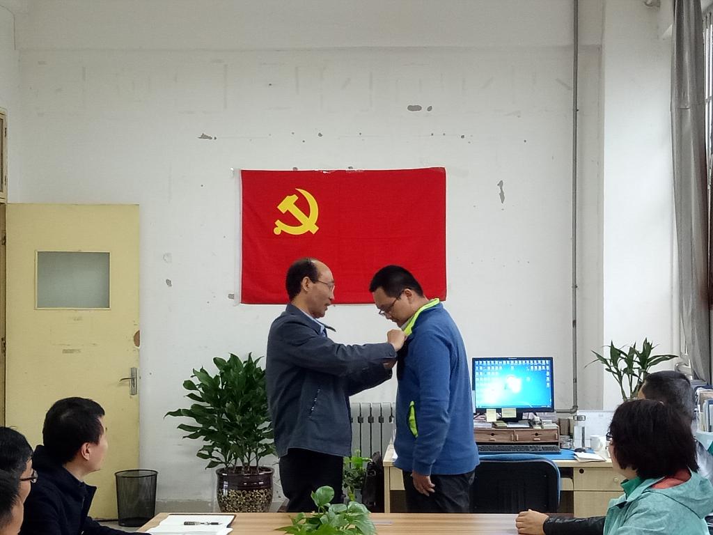 郝红武为学生党员代表佩戴党徽